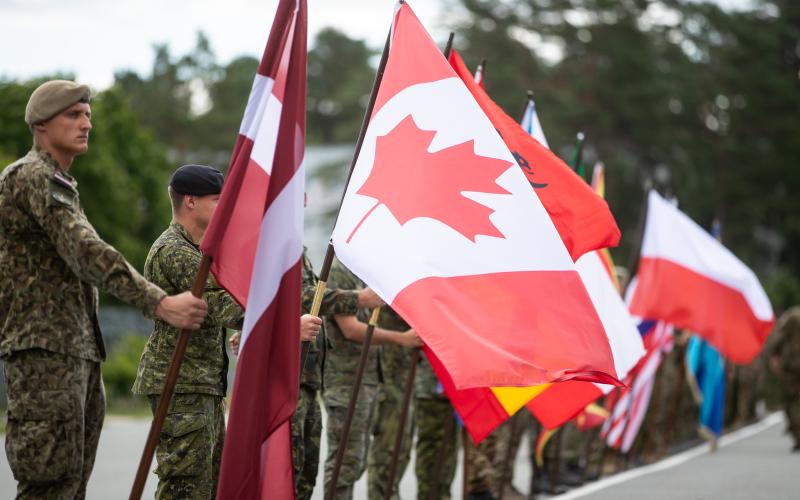 Soldiers of NATO enhanced Forward Presence Battle Group Latvia with national flags
